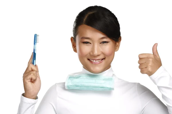 Sonriendo joven asiático mujer dentista mostrando un cepillo de dientes — Foto de Stock