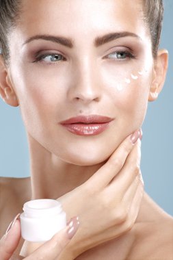 güzel bir kadın mükemmel yüzünde krem tedavisi uygulanıyor