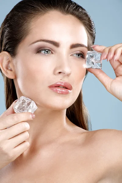 Mulher bonita aplicando tratamento cubo de gelo no rosto — Fotografia de Stock