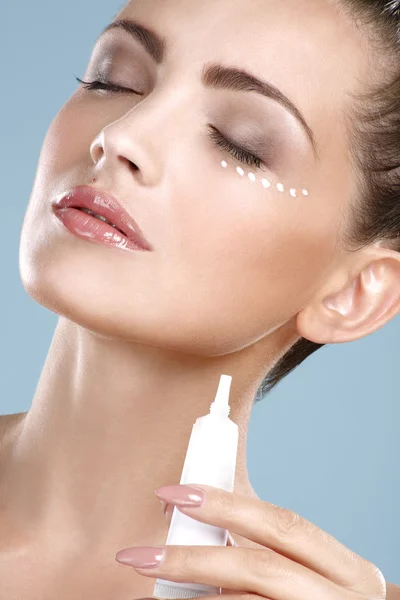 Beautiful woman applying cream treatment on her perfect face — Stock Photo, Image