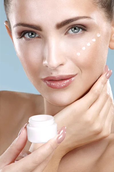 Hermosa mujer aplicando tratamiento de crema en su cara perfecta — Foto de Stock