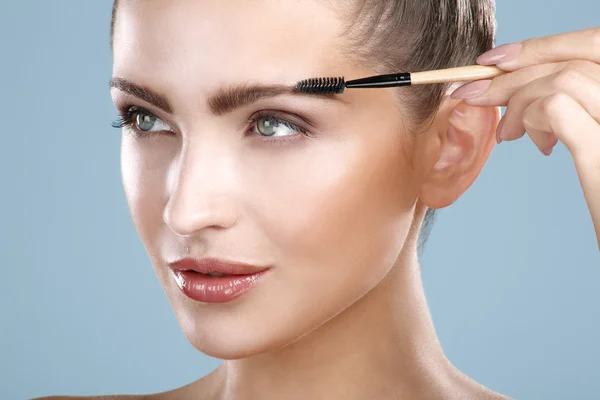Primer plano hermosa mujer con herramienta de cepillo de cejas —  Fotos de Stock