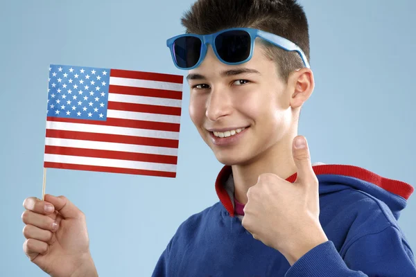 Jovem sorrindo estudante do sexo masculino adolescente segurando uma bandeira — Fotografia de Stock
