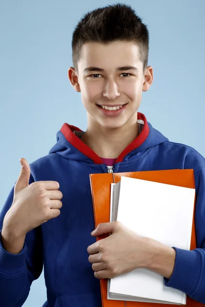 Jovem sorrindo estudante do sexo masculino adolescente segurando um livro — Fotografia de Stock