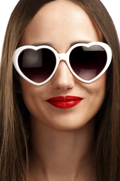 Giovane ragazza sorridente con occhiali a forma di cuore — Foto Stock
