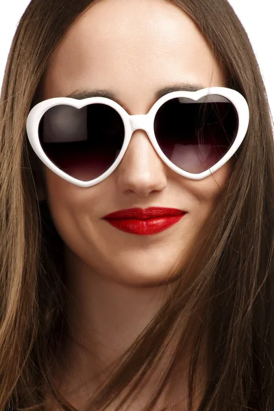 Giovane ragazza sorridente con occhiali a forma di cuore — Foto Stock