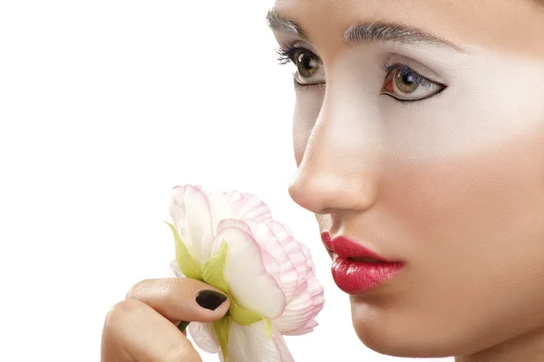 Hermosa chica oliendo una flor con un maquillaje de sombra de ojos blanco —  Fotos de Stock