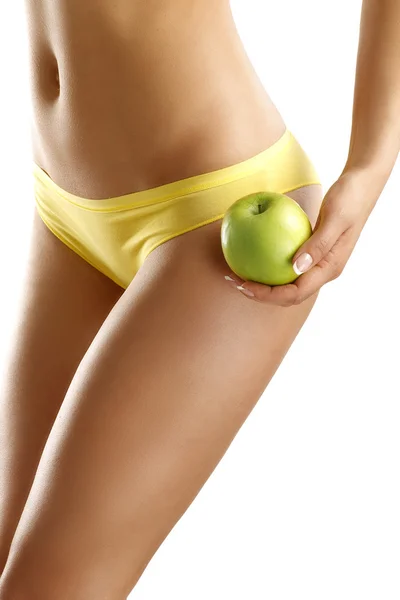 Close up of a woman showing hips with a fruit in her hand — Stock Photo, Image
