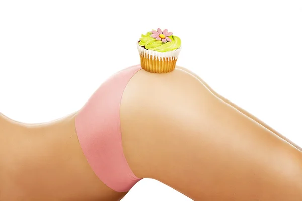 Primo piano su una ragazza che mostra un cupcake sul suo corpo — Foto Stock