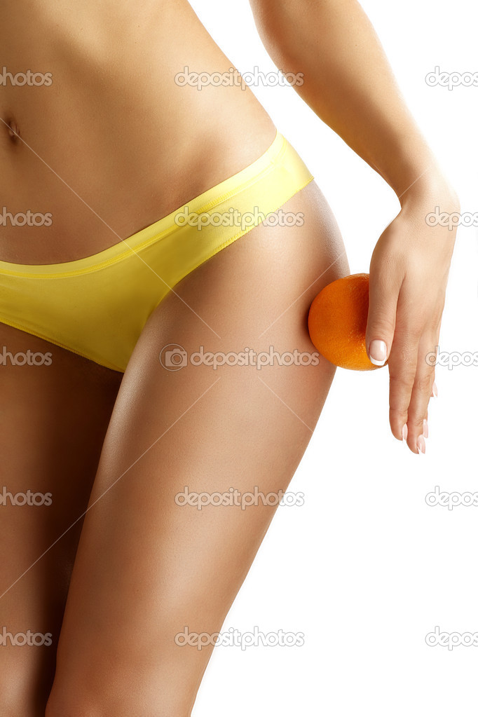 Close up of a woman showing hips with a fruit in her hand
