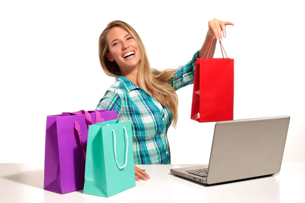 Молодая женщина сидит за столом покупки онлайн — стоковое фото