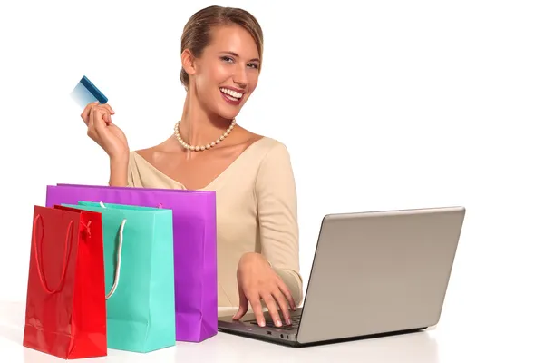 Online alışveriş masa başında oturan genç kadın — Stok fotoğraf