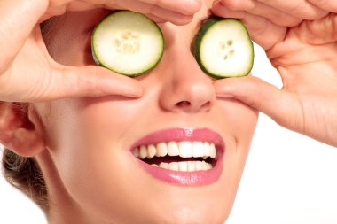 Genç beautiflul gülümseyen kız salatalık güzellik treatme uygulanması