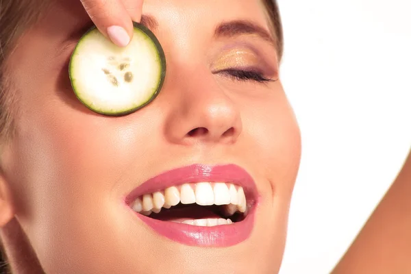 Jonge beautiflul lachende meisje toe te passen een komkommer schoonheid treatme — Stockfoto