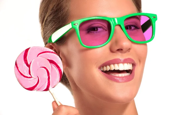 Mooi meisje genieten van een grote kleurrijke snoep — Stockfoto