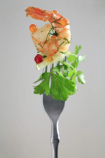 Shrimp, cucumber, parsley are on the fork — Photo