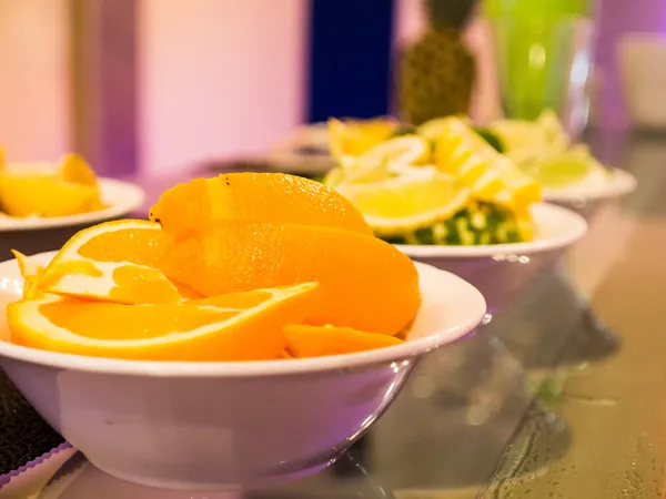View of fresh orange, lime and lemons in white bowl on long drink bar — Stock Photo, Image