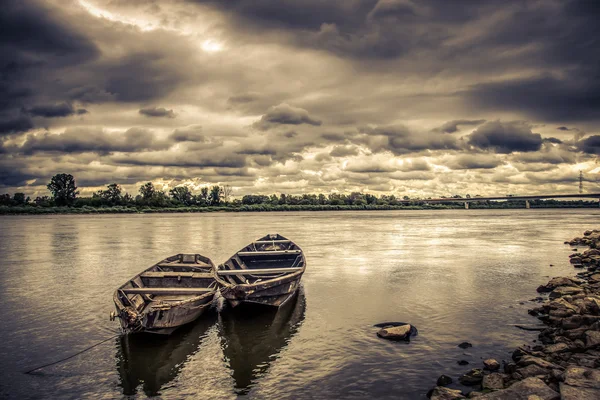 Alte Boote auf dem Fluss, stürmisches Wetter lizenzfreie Stockbilder