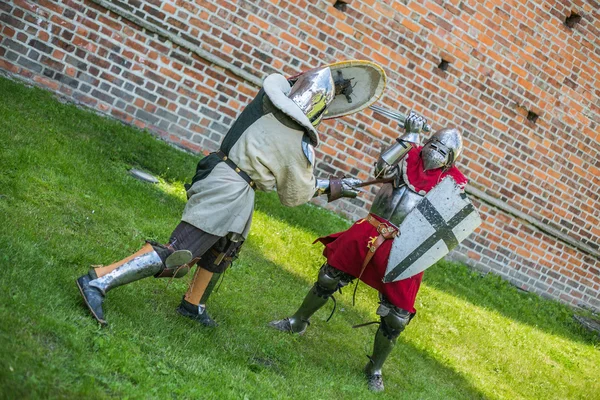 zırhlı şövalyeler arka planda Ortaçağ Kalesi ile mücadele