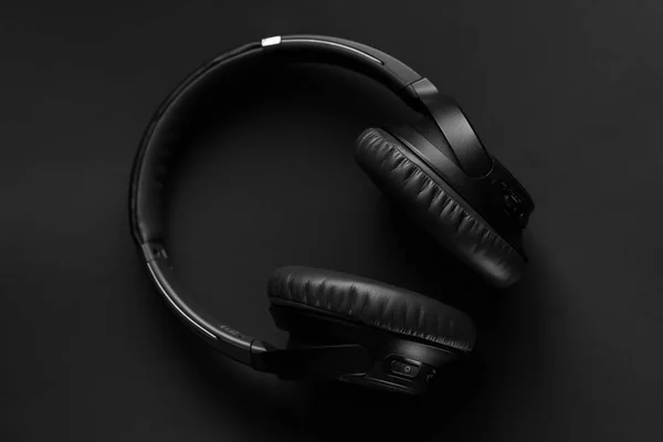 黒い背景の黒いワイヤレスヘッドフォン ロイヤリティフリーのストック画像