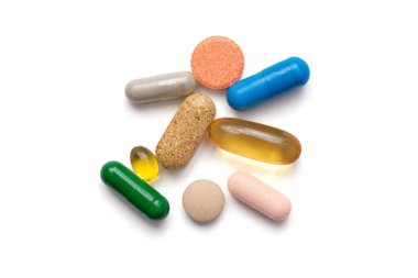 Beyaz arka planda renkli haplar ve vitaminler