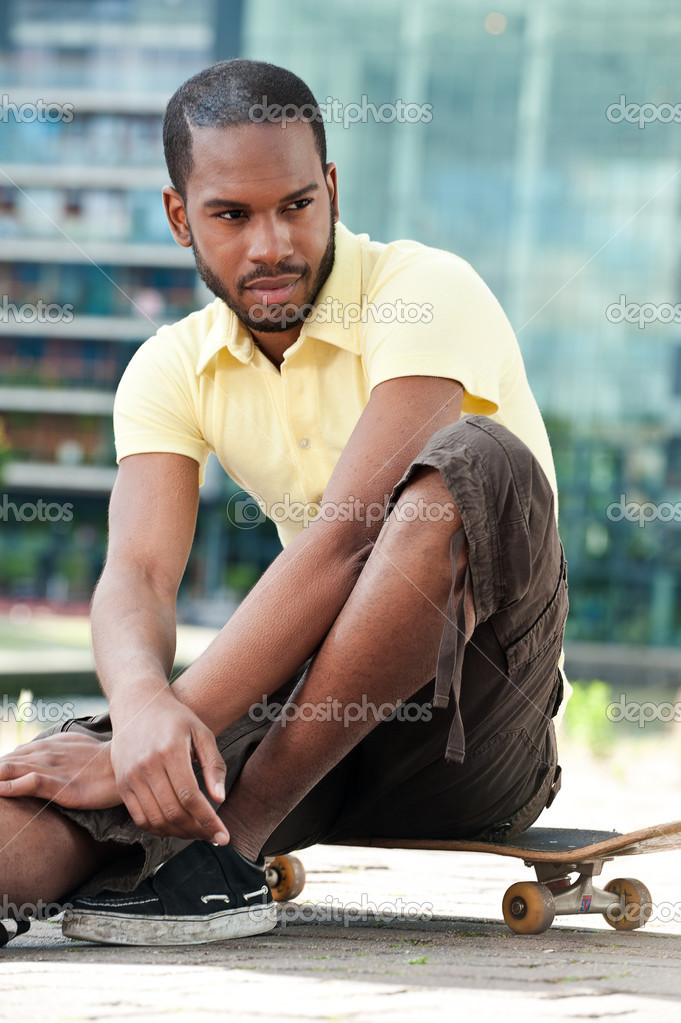 Young Black Male Sitting on Skateboard