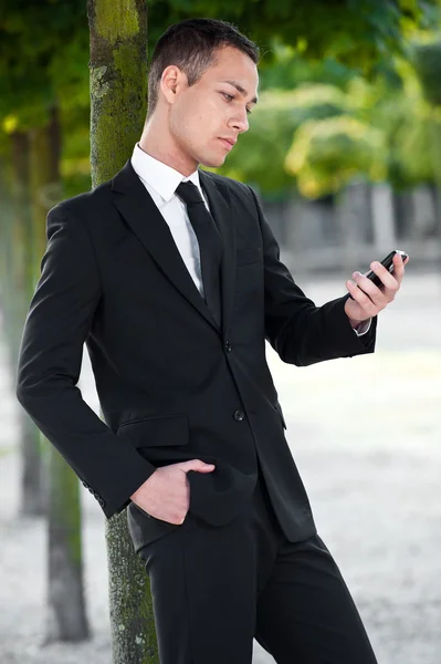 Affärsman tittar på sin telefon — Stockfoto