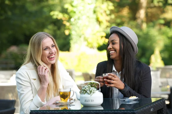 Amigos multiculturales riendo y bebiendo té — Foto de Stock