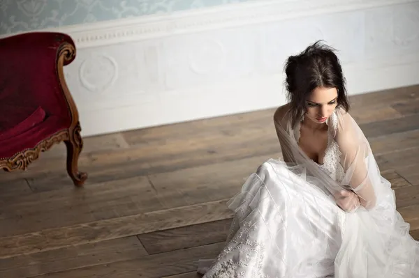 Retrato de una hermosa novia sentada en un piso de madera — Foto de Stock