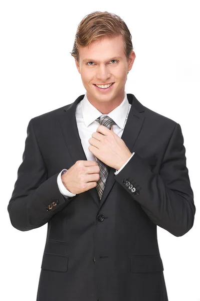 Привлекательный бизнесмен улыбается и держит галстук — стоковое фото