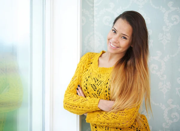 Mulher bonita sorrindo pela janela — Fotografia de Stock