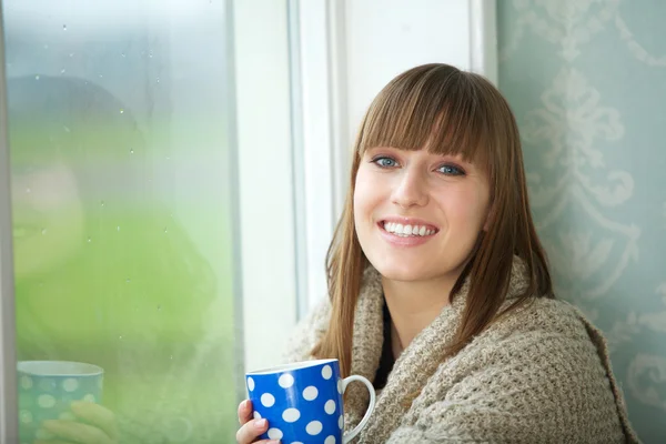 Hermosa joven sonriendo con una taza de té — Foto de Stock