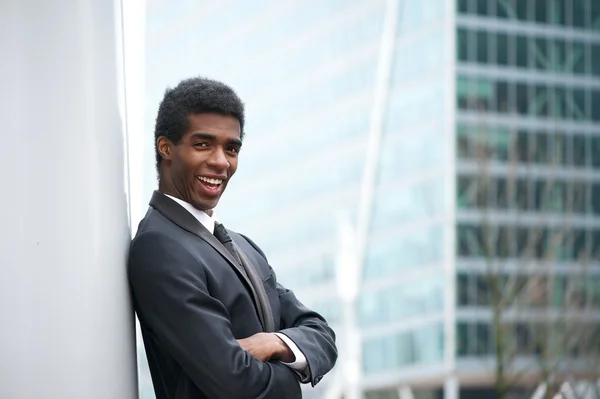 Guapo joven hombre de negocios afroamericano sonriendo en la ciudad —  Fotos de Stock