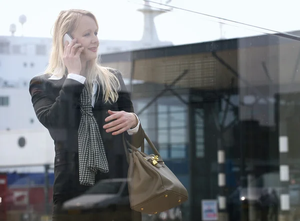 Mooie oudere vrouw praten op mobiele telefoon buitenshuis — Stockfoto