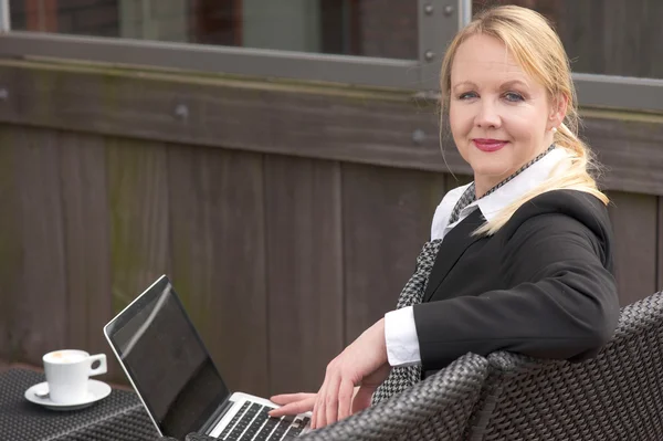 Mulher de negócios relaxante com laptop e xícara de café ao ar livre — Fotografia de Stock