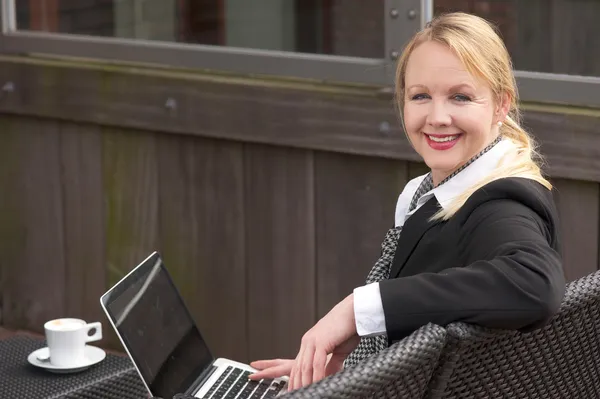 Glückliche Geschäftsfrau mit Laptop und Tasse Kaffee im Freien — Stockfoto