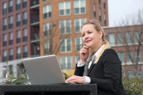 Mujer de negocios moderna sentada con portátil al aire libre —  Fotos de Stock