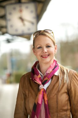 tren istasyonu saatin altında gülümseyen güzel yaşlı bir kadın portresi