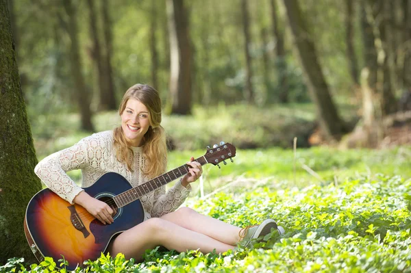 Açık havada gitar çalmaya mutlu bir genç kadının portresi — Stok fotoğraf