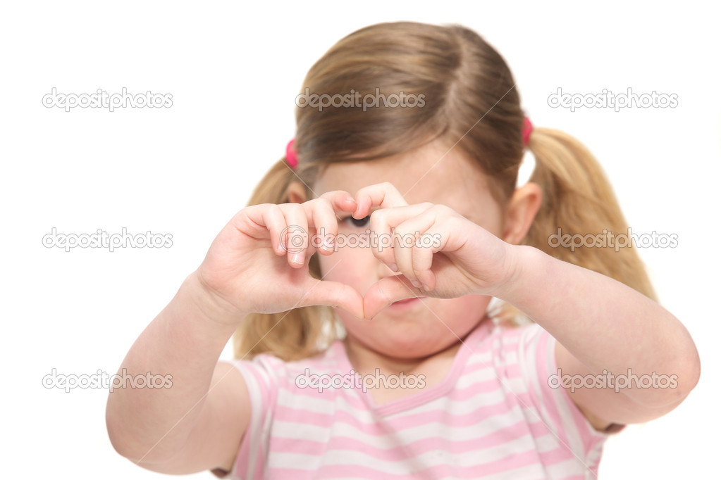 Portrait of a cute little girl showing heart shape sign with fingers