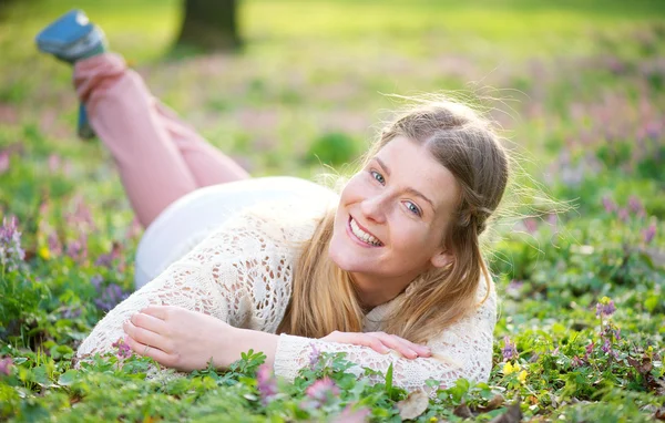 Portret młodej kobiety, leżąc na trawie na zewnątrz — Zdjęcie stockowe