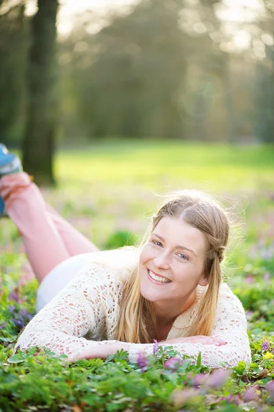 Portret als een gelukkig vrouw liggen op gras buitenshuis — Stockfoto