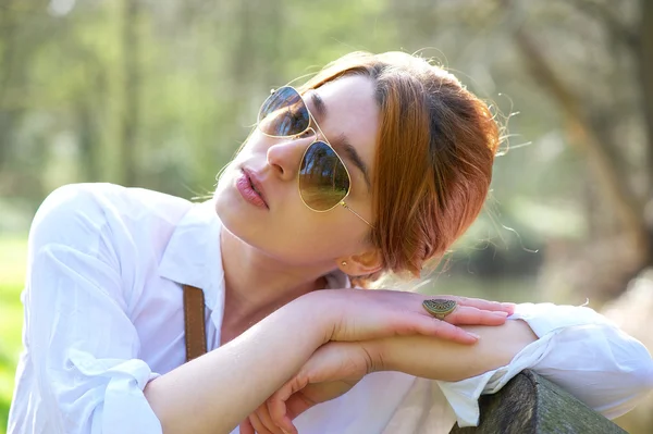 Beautiful woman with sunglasses relaxing outdoors — Stock Photo, Image