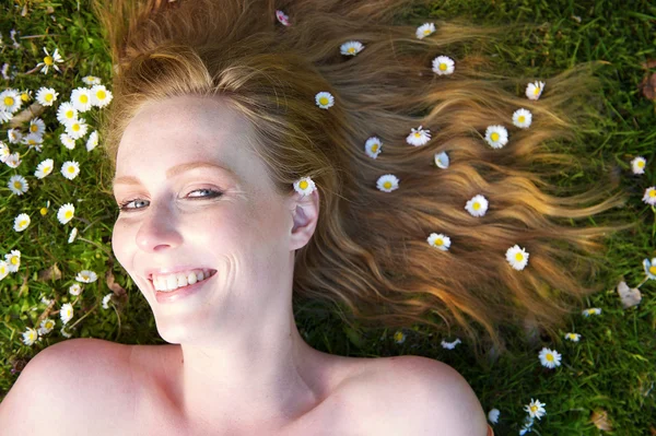 Close up retrato de uma mulher feliz sorrindo com flores no cabelo — Fotografia de Stock