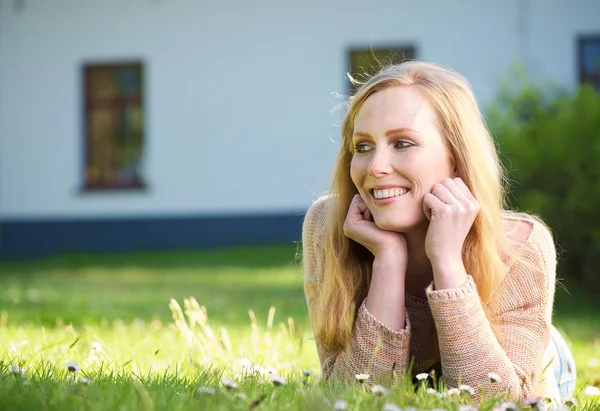 Mujer feliz acostada en la hierba al aire libre y sonriendo —  Fotos de Stock