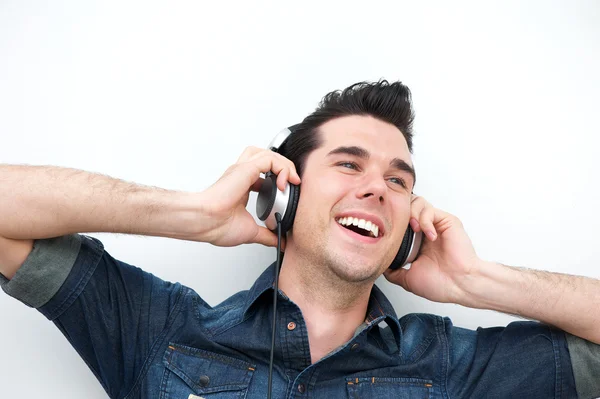 Portréja egy mosolygó ember hallgat zenét a fejhallgatót — Stock Fotó