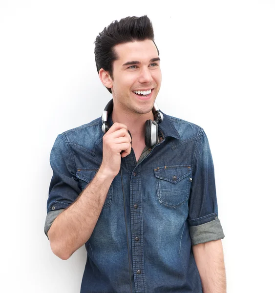 Retrato de un joven guapo sonriendo con auriculares — Foto de Stock