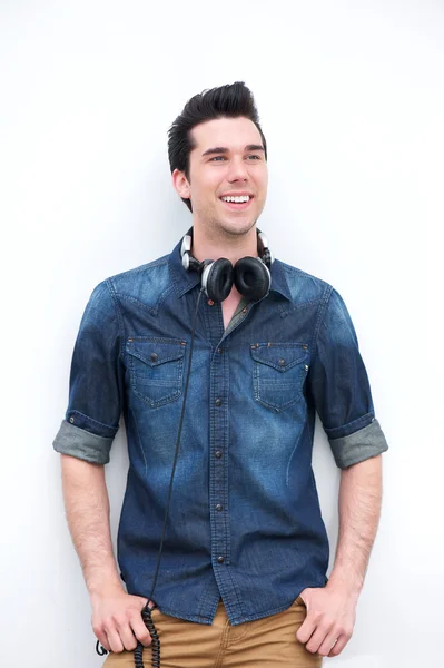 Handsome young man standing outdoors with a pair of headphones — Stock Photo, Image