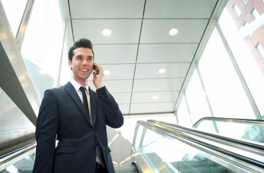 yürüyen merdiven telefonda konuşurken işadamı