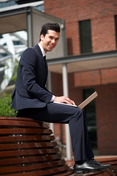 Hombre de negocios feliz trabajando en el ordenador portátil fuera de la oficina — Foto de Stock